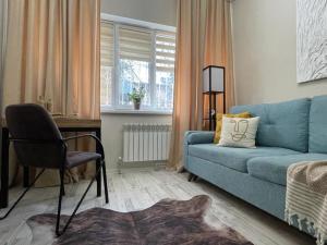 a living room with a blue couch and a chair at Apart Complex Молодежный из 20 отдельных апартаментов в центре города in Almaty