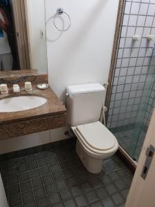 a bathroom with a toilet and a sink and a shower at Apto resort de Angra in Mangaratiba +18 photos