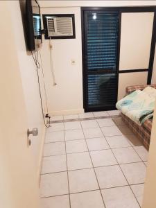 a room with a tiled floor and a door with a bed at Apto resort de Angra in Mangaratiba