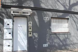a gray building with a door and a window at Natullins Apartment in Ezeiza