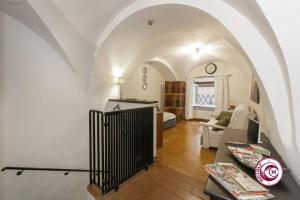 ein Wohnzimmer mit einem Torbogen mit einem Sofa und einem Tisch in der Unterkunft Palazzo Scapucci Apartment a Navona in Rom