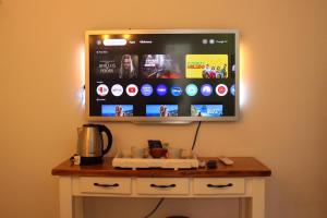 a flat screen tv hanging on a wall at Natullins Apartment in Ezeiza
