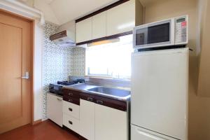 a kitchen with a sink and a microwave at Shinjuku Urban Hotel in Tokyo