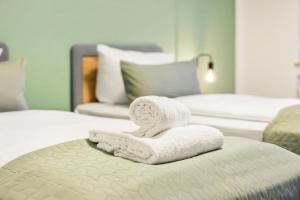 a pile of towels sitting on top of a bed at Salí Homes Weinblick Beethoven - ruhige Feldlage in Obersulm