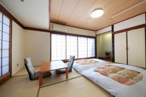 東京にある新宿アーバンホテルのベッド2台とテーブルと窓のある部屋