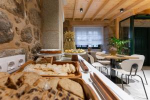 aastery with bread and tables and chairs in a room at Hostal HCELENIS in Caldas de Reis