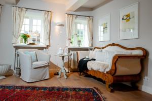 a bedroom with a bed and a chair and windows at Sylter Seestern Haus Deichblick in Morsum +12 photos