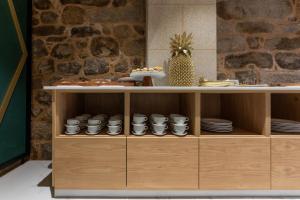 a wooden cabinet with cups and plates on it at Hostal HCELENIS in Caldas de Reis