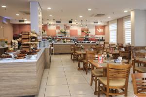 a restaurant with wooden tables and chairs and a bakery at NB Hoteis in Aracaju
