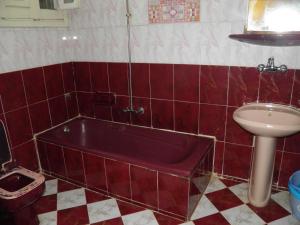 a red tiled bathroom with a tub and a sink at لؤلؤه الفيروز in Marsa Matruh