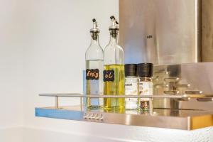 three bottles of alcohol sitting on a metal shelf at Salí Homes Weinblick Beethoven - ruhige Feldlage in Obersulm