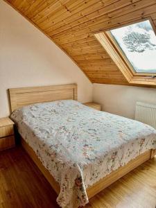 a bedroom with a bed with a window at Bakuriani Haystack Apartment 219 Rooftop Views in Bakuriani