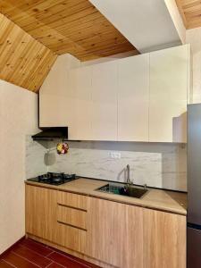 a kitchen with white cabinets and a sink at Bakuriani Haystack Apartment 219 Rooftop Views in Bakuriani