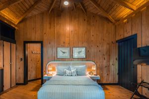 a bedroom with a large bed with wooden walls at The Grand Forest Jarabacoa in Jarabacoa +122 photos
