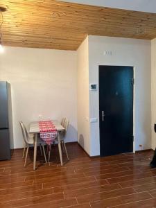 a dining room with a table and chairs and a black door at Bakuriani Haystack Apartment 219 Rooftop Views in Bakuriani