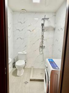a white bathroom with a toilet and a shower at Bakuriani Haystack Apartment 219 Rooftop Views in Bakuriani