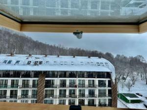 a view of a building with snow on the roof at Bakuriani Haystack Apartment 219 Rooftop Views in Bakuriani