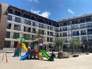 a group of playground equipment in front of a building at Bakuriani Haystack Apartment 219 Rooftop Views in Bakuriani
