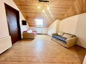 a large living room with a couch and a door at Bakuriani Haystack Apartment 219 Rooftop Views in Bakuriani