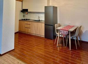 a kitchen with a table with chairs and a refrigerator at Bakuriani Haystack Apartment 219 Rooftop Views in Bakuriani