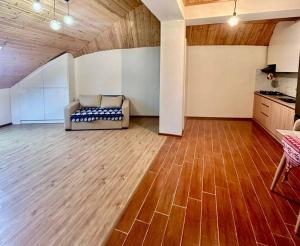 a living room with a couch and a wooden floor at Bakuriani Haystack Apartment 219 Rooftop Views in Bakuriani