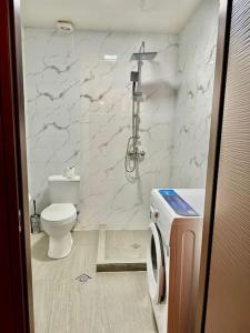 a white bathroom with a toilet and a shower at Bakuriani Haystack Apartment 219 Rooftop Views in Bakuriani
