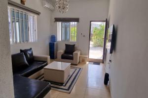 OtokutuTropicana Resorts and Gardens 1的带沙发、椅子和桌子的客厅