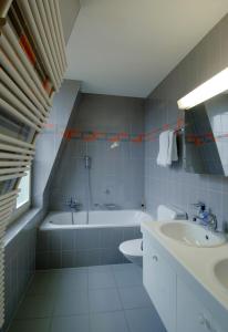 a bathroom with a tub and a toilet and a sink at Luxury Apartments Justingerweg Bern in Bern