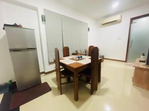 a dining room with a table and chairs and a refrigerator at The Motel Express - Colombo Border in Wattala