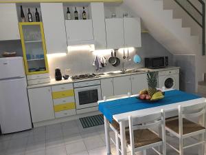 a kitchen with a table with a bowl of fruit on it at Casa Vacanza - I Borghi in Villasimius