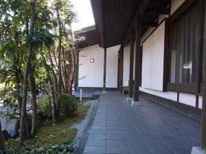 a walkway next to a building with trees on it at Pension Amagiji in Izu