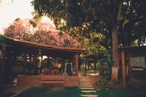 a wooden pavilion with a tree and a bench at Pousada Chalés do Rancho Canastra in Vargem Bonita