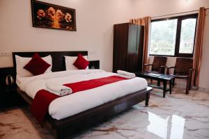 una camera da letto con un letto grande con una coperta rossa di Corbett Nature Walk - Forest View Swimming Pool a Ramnagar