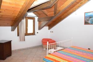 a bedroom with a bed and a chair in a room at Agriturismo il Pettirosso in Pianillo