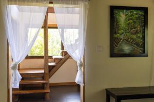 a room with a staircase and a window with white curtains at Cascadas Corcovado - luxury villa in Charcos