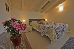 a bedroom with a bed and a potted plant at Casa Rita Fonteno in Fonteno