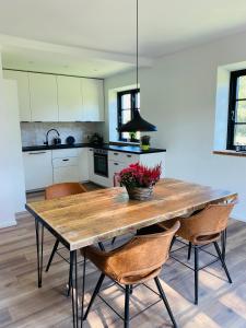 a kitchen with a wooden table and chairs at Ferienhaus im Treenetal - zwischen Nordsee und Ostsee in Treia