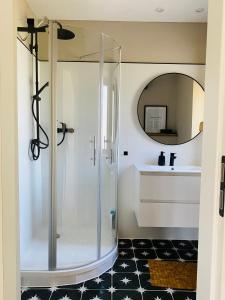 a glass shower in a bathroom with a black and white floor at Ferienhaus im Treenetal - zwischen Nordsee und Ostsee in Treia