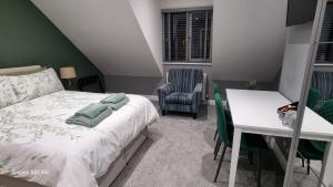 a bedroom with a bed and a desk and a chair at Causeway Rooms in Ballybogy