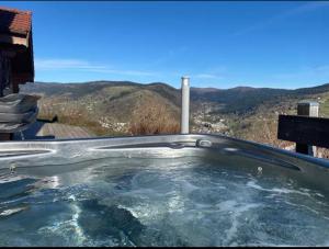 a hot tub with a view of the mountains at Chalet Solie in La Bresse