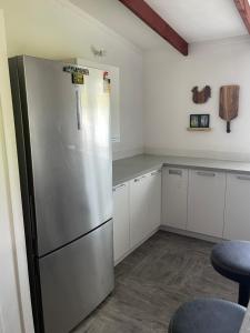 een keuken met een roestvrijstalen koelkast en witte kasten bij Are Rera's Holiday Homestead in Rarotonga