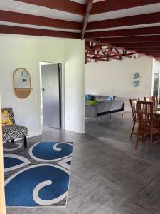 een woonkamer met een tafel en stoelen en een tapijt bij Are Rera's Holiday Homestead in Rarotonga