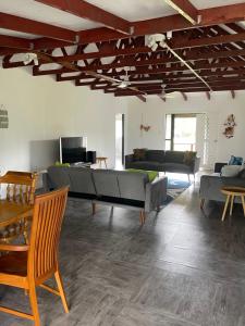 een woonkamer met een grote bank en een tafel bij Are Rera's Holiday Homestead in Rarotonga +47 foto's