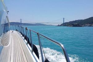 ein Boot auf dem Wasser mit einer Brücke im Hintergrund in der Unterkunft Vip Bosphorus Tour in Istanbul