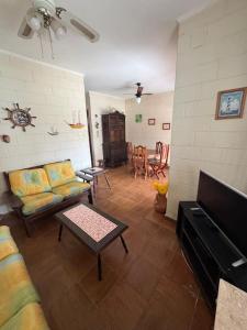 a living room with a couch and a table at Casa Praia Riviera São Lourenço in Bertioga