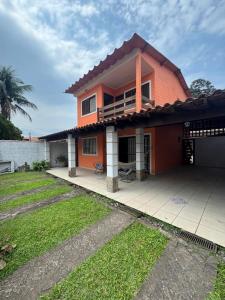 a house with a large patio in a yard at Casa Praia Riviera São Lourenço in Bertioga +35 photos
