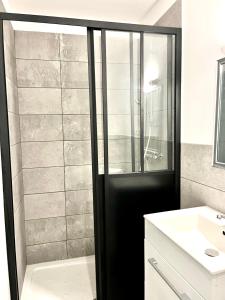 un bagno con doccia e lavandino bianco di "L'Echapée Belle" Maison de village climatisée de 45m2 à proximité de Carcassonne,1 chbre à l'étage vue panoramique sur les pyrénées, cuisine équipée,1Salon,1 sdb, Wifi, Parking gratuit, Netflix,Canal sat, Fauteuil massant a Montréal