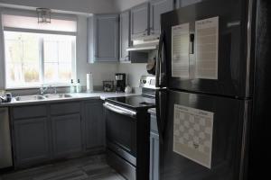 una cucina con frigorifero nero e lavandino di Rustic Hive - Wyoming a Casper