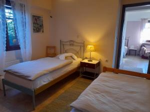 a bedroom with two beds and a lamp on a table at Anta's bnb in Ambelókipoi