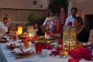 un grupo de personas sentadas alrededor de una mesa con comida en Riad El Koudia, en Douar el Koudia